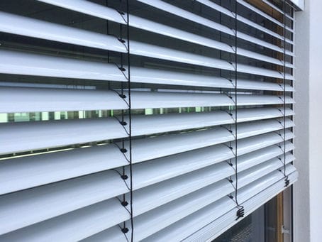 Buitenzonwering op een gevel houdt de zon tegen bij een modern gebouw
